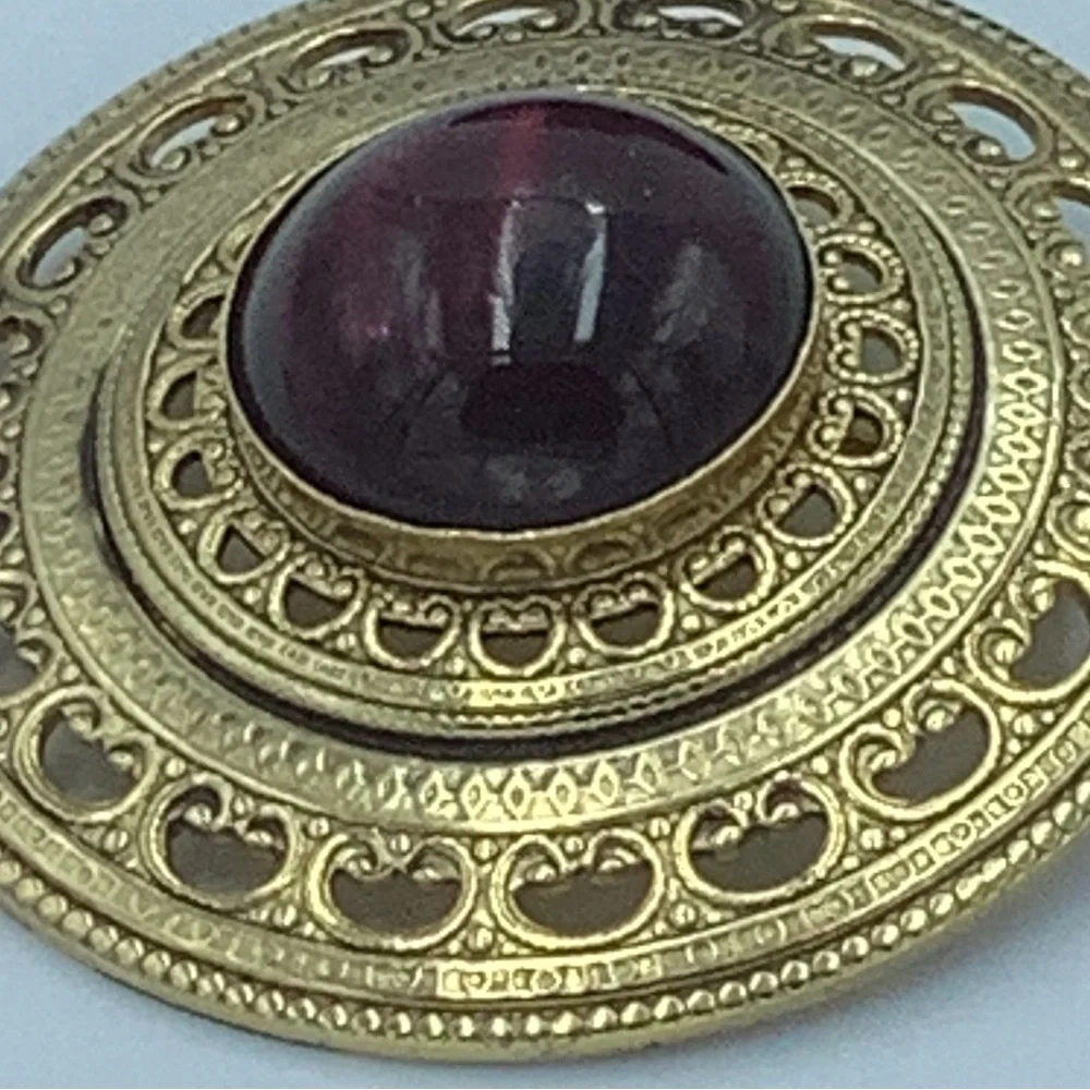 Gold Tone Round Filigree Brooch with Red/Purple Stone